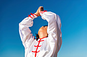 Women practicing tai chi by lake