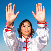 Women practicing tai chi by lake