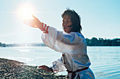 Women practicing tai chi by lake