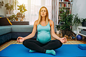 Pregnant woman doing yoga at home