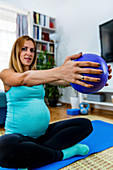 Pregnant woman doing pilates at home