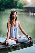 Woman meditating by a lake