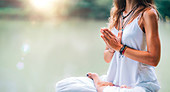 Woman meditating by a lake