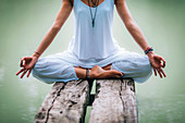 Woman meditating by a lake