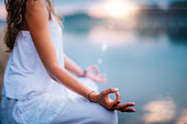 Woman meditating by a lake