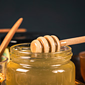 Honey glass jar with wooden dipper