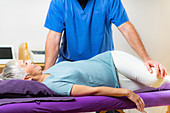 Physical therapist stretching senior woman