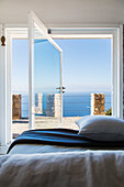 Blick vom Schlafzimmer durchs offene, schwenkbare Fenster aufs Meer
