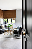 View through open panelled door with doorknob leading into elegant living room