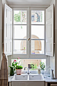 Spüle vor Sprossenfenster mit weißen Innen-Fensterläden