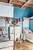 Festively decorated siblings' bedroom with blue wall in renovated farmhouse