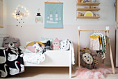 Bett und Garderobe im zeitgenössischen Kinderzimmer in Pastelltönen