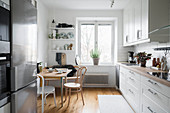 Bistro chairs at small table in bright kitchen-dining room