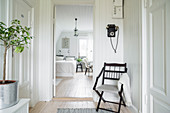 Chair next to bedroom door in hallway with period charm