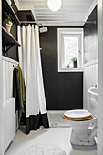 Small shower bathroom with black walls and white floor