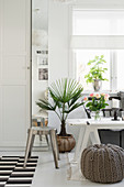 Stool and pouffe around bench used as coffee table in living room