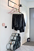 Shoe rack made from pipes bound with lashing strap below coat rack