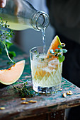 Water kefir lemonade with candied melon and lemon balm