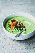 Pea and mint soup with vegetable chips and cream fraiche