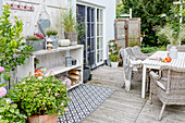 Garden furniture, outdoor rug and wooden shelves on terrace in autumn