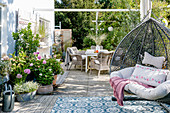 Terrasse im Herbst mit Terrassenmöbeln, Outdoor-Teppichen und Hängesessel