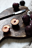 Fresh plums on a wooden chopping board