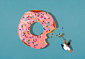 Mann kehrt Zuckerstreusel vom Donut zusammen (Illustration)