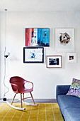 Sitzbereich vor Bilderwand mit Designer-Schaukelstuhl und Couch