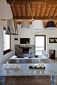 Dining table, fireplace and wooden ceiling in Tuscan-style living room