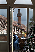 View from festively decorated interior over roofs to lake