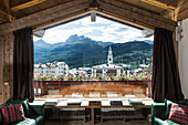 View of mountain village through panoramic window of chalet