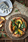Delicious fresh summer pizza placed on timber table in rustic kitchen