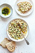 Creamy white bean with herb oil on the table, top view