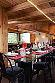 Festively set table with black upholstered chairs in dining area of chalet