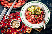 Beetroot vegan risotto with sunflower seeds and courgette