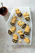 Butter biscuits dipped in dark chocolate and sprinkled with pistachios nuts on a cooling rack