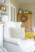 White armchair in living room with autumnal decorations