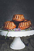 Mini Bundt cakes with blackberries and lavender on a cake stand