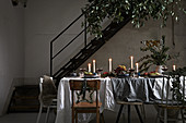 Festively set, candlelit dining table in loft-apartment interior