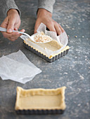 Rectangular shortcrust tart bases being prepared for blind baking