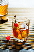 Old fashioned cocktail, whiskey on the rocks with bitters, orange and marashino cherry