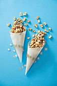 Christmas popcorn with maple syrup, cinnamon and orange zest in a paper cone