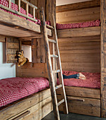 Rustic bunk beds made from reclaimed wood with red gingham bed linen