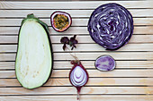 Flatlay of purple fruits and vegetables arranged on a wooden background