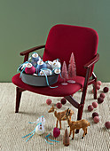 Numbered Christmas tree baubles on red upholstered chair