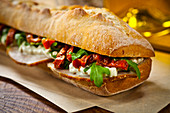 Baguette-Sandwich mit Aufschnitt, Tomaten und Rucola