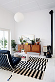 Numerous houseplants on retro sideboard in black-and-white living room