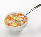 Chicken vegetable soup with small shell pasta.