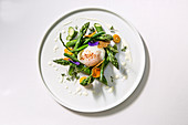Softly poached egg with green vegetable and kumquats