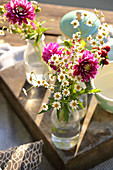Gartenblumen in Glasflaschen als Deko fürs Picknick am See